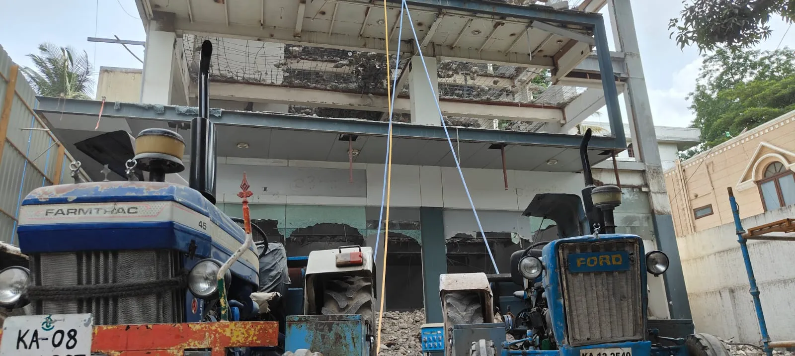 Concrete demolition services in Bangalore — Urban Eco Recyclers operator carrying out RCC roof slab breaking with a hydraulic breaker