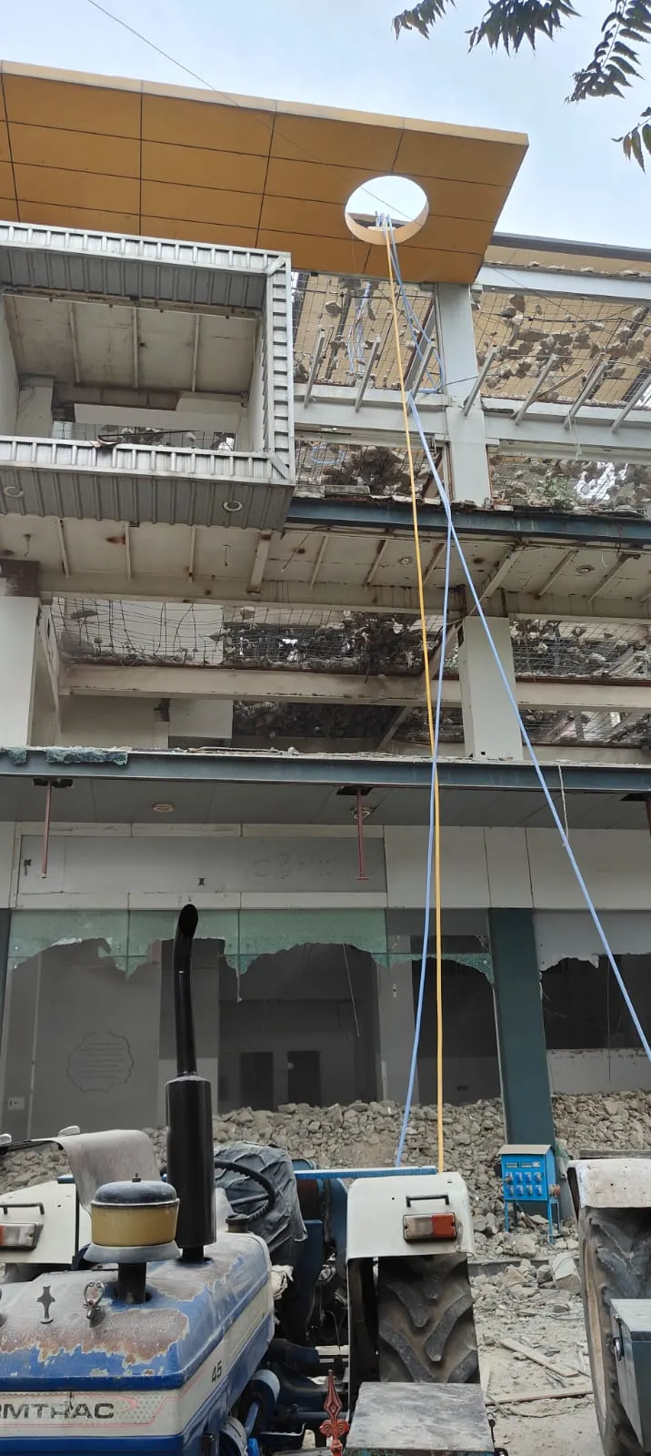 Complete site demolition services in Bangalore — Urban Eco Recyclers excavator carrying out RCC breaking on a multi-storey building