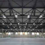 Event and Exhibition Stall Dismantling Services in Bangalore A massive, brightly lit empty exhibition hall in Bangalore after complete event structural dismantling and floor clearing.