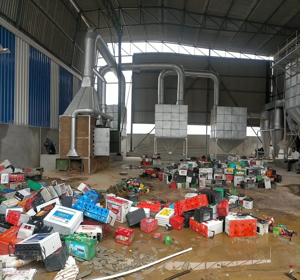 Scrap lead-acid automotive and industrial batteries piled on the floor of a smelting 