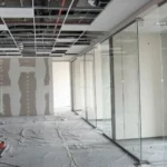 showroom-dismantling-services-in-bangalore Professional interior showroom dismantling and retail space strip-out by Urban Eco Recyclers in Bangalore, featuring exposed ceiling grids and glass partition walls.