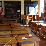 School College Dismantling Services in Bangalore Rows of school desks and benches inside a classroom prepared for institutional inventory liquidation and scrap collection.