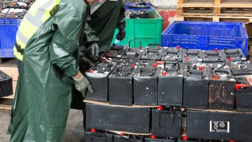 Workers handling heavy lead-acid vehicle and UPS batteries at a professional hazardous scrap recycling center in Bangalore by Urbane Eco Recyclers
